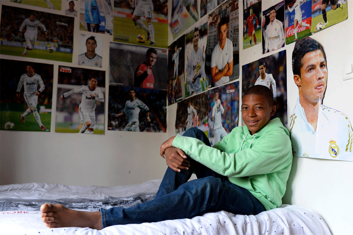  Kylian Mbappe poses with his posters of hero Cristiano Ronaldo